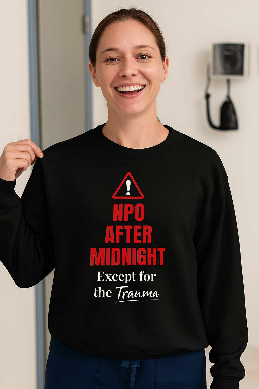 Funny nurse sweatshirt with quote “NPO After Midnight (Except for the Trauma),” worn by exhausted RN dodging chaos at 2 a.m.