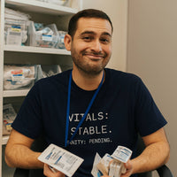 Nurse in scrubs laughing and counting a fat stack of cash while wearing “Vitals Stable. Sanity Pending.” shirt, payday energy for burnout relief