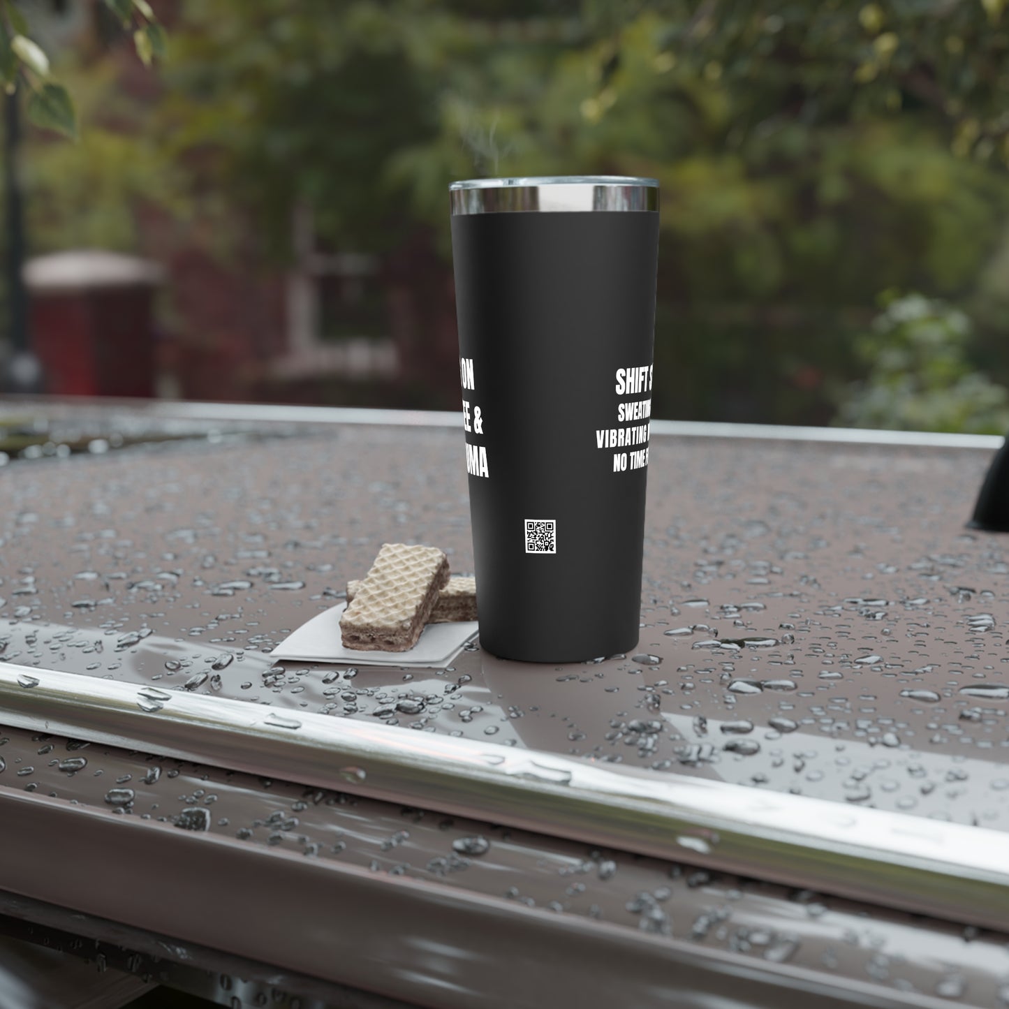 black stainless tumbler with PRN Coffee quote placed on the top of a parked car, surrounded by light rain.