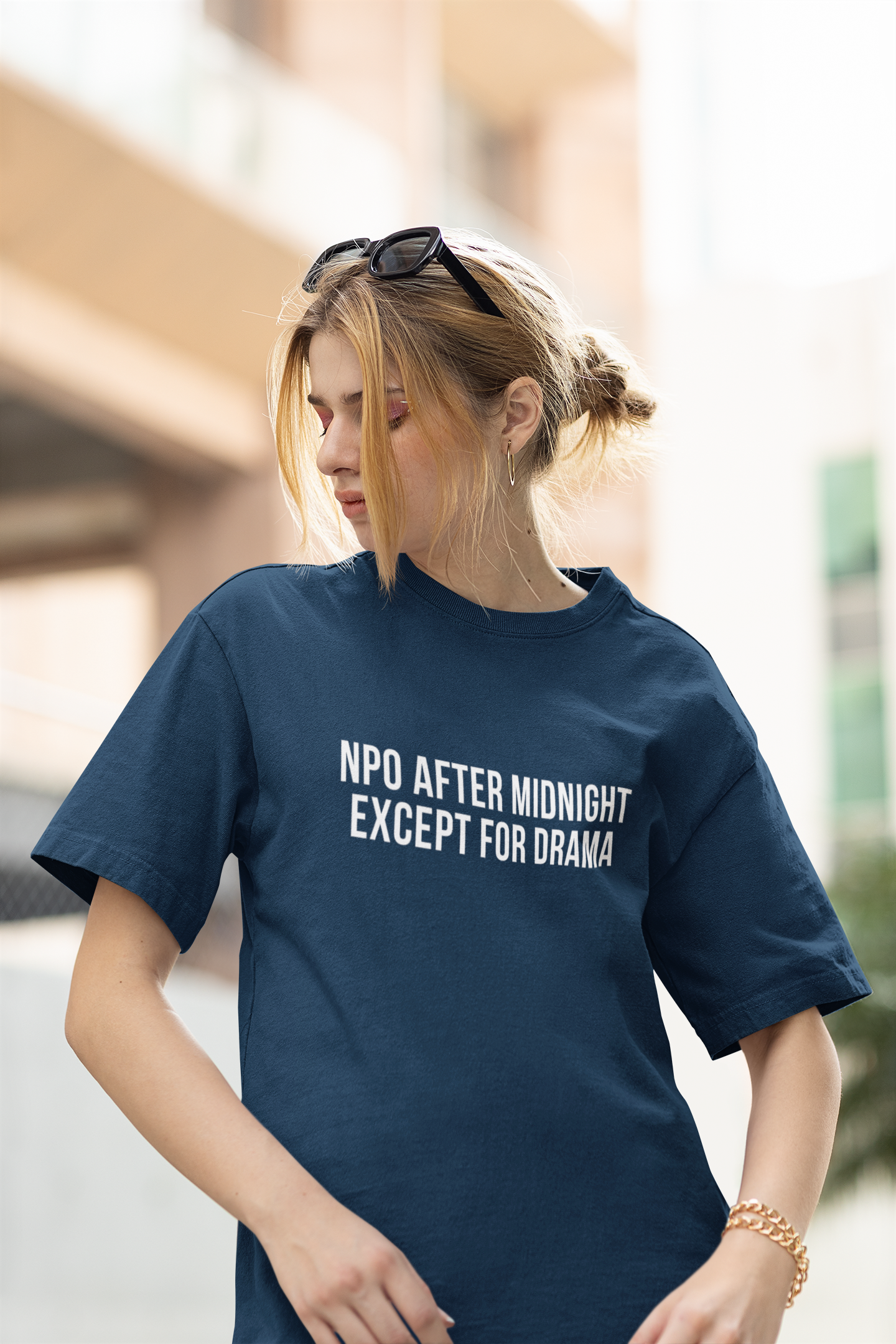 Nurse standing in blue burnout tee that reads “NPO AFTER MIDNIGHT, EXCEPT FOR DRAMA.”
