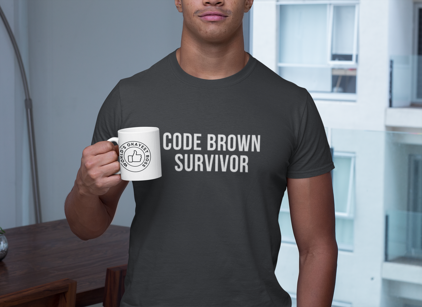 Smiling nurse in grey shirt sipping coffee; “Code Brown Survivor” text visible on chest.