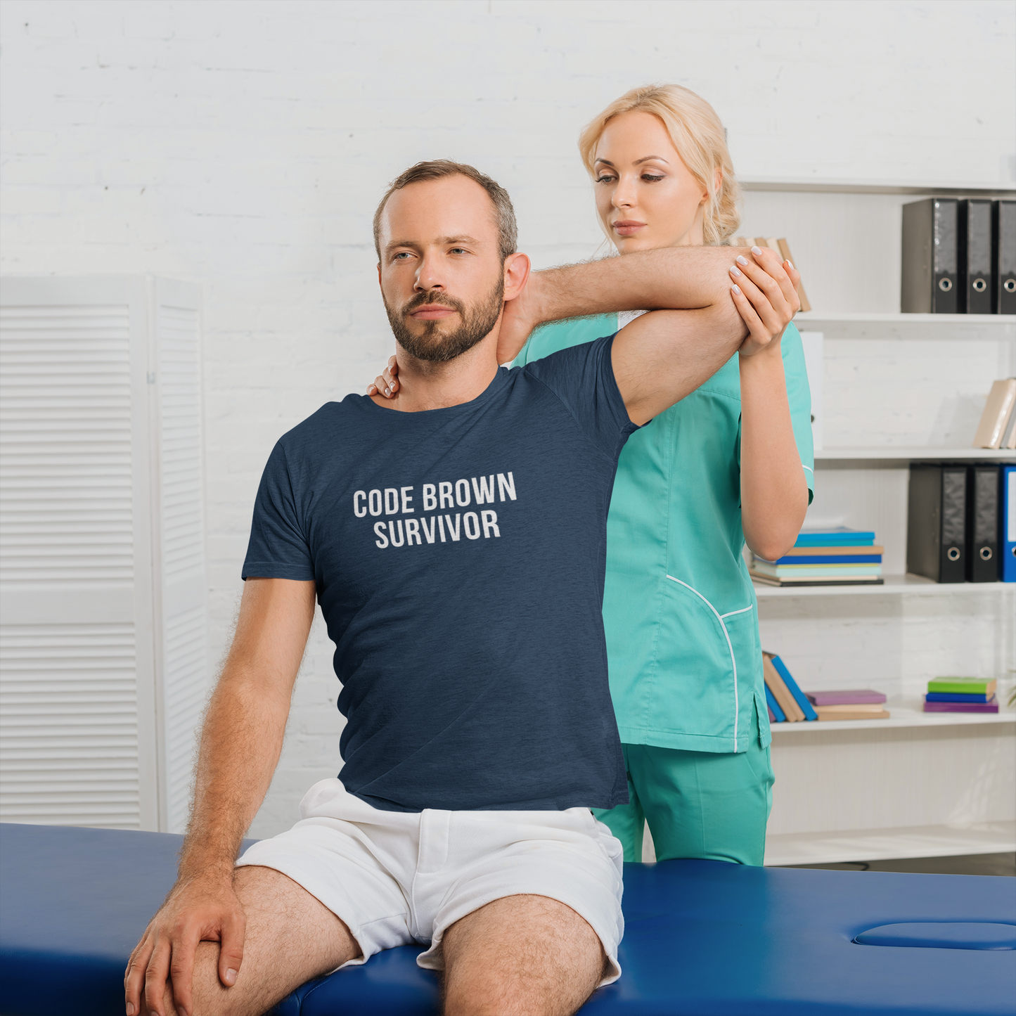 Nurse on call in patient room wearing teal burnout tee: “Code Brown Survivor.”