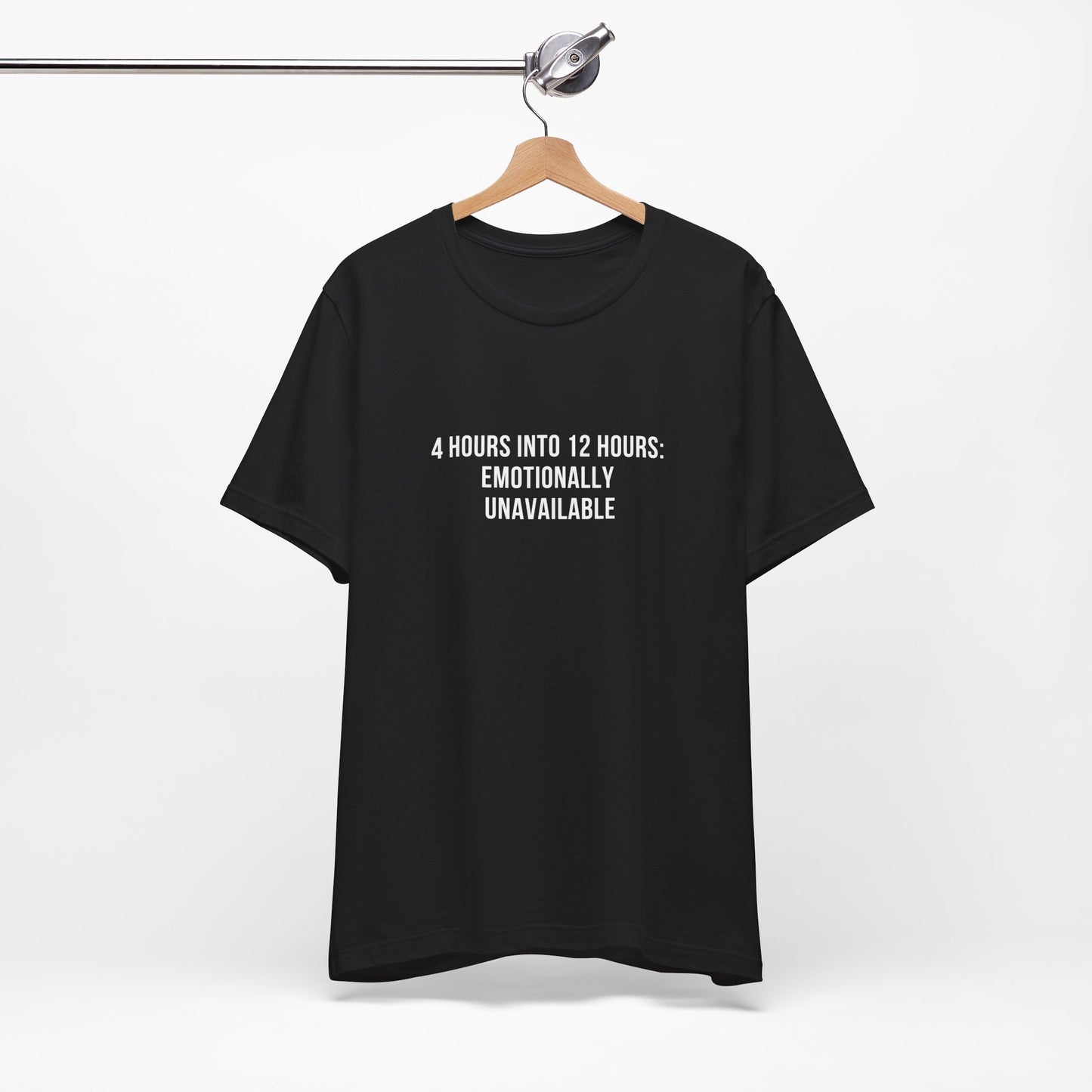 Flatlay of black “Emotionally Unavailable” t-shirt hanging on wooden hanger.