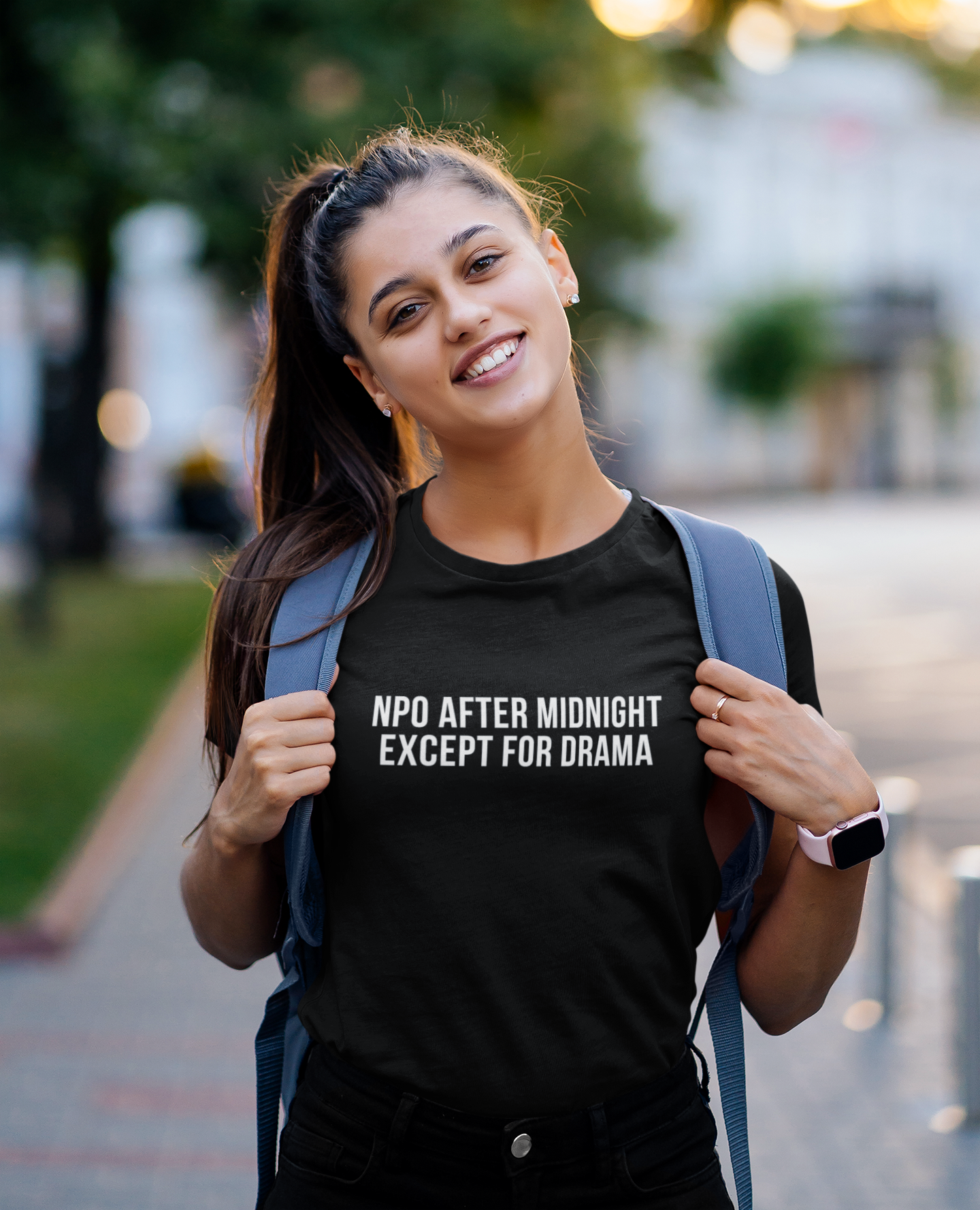 Nurse standing and smiling in black burnout tee that reads “NPO AFTER MIDNIGHT, EXCEPT FOR DRAMA.”