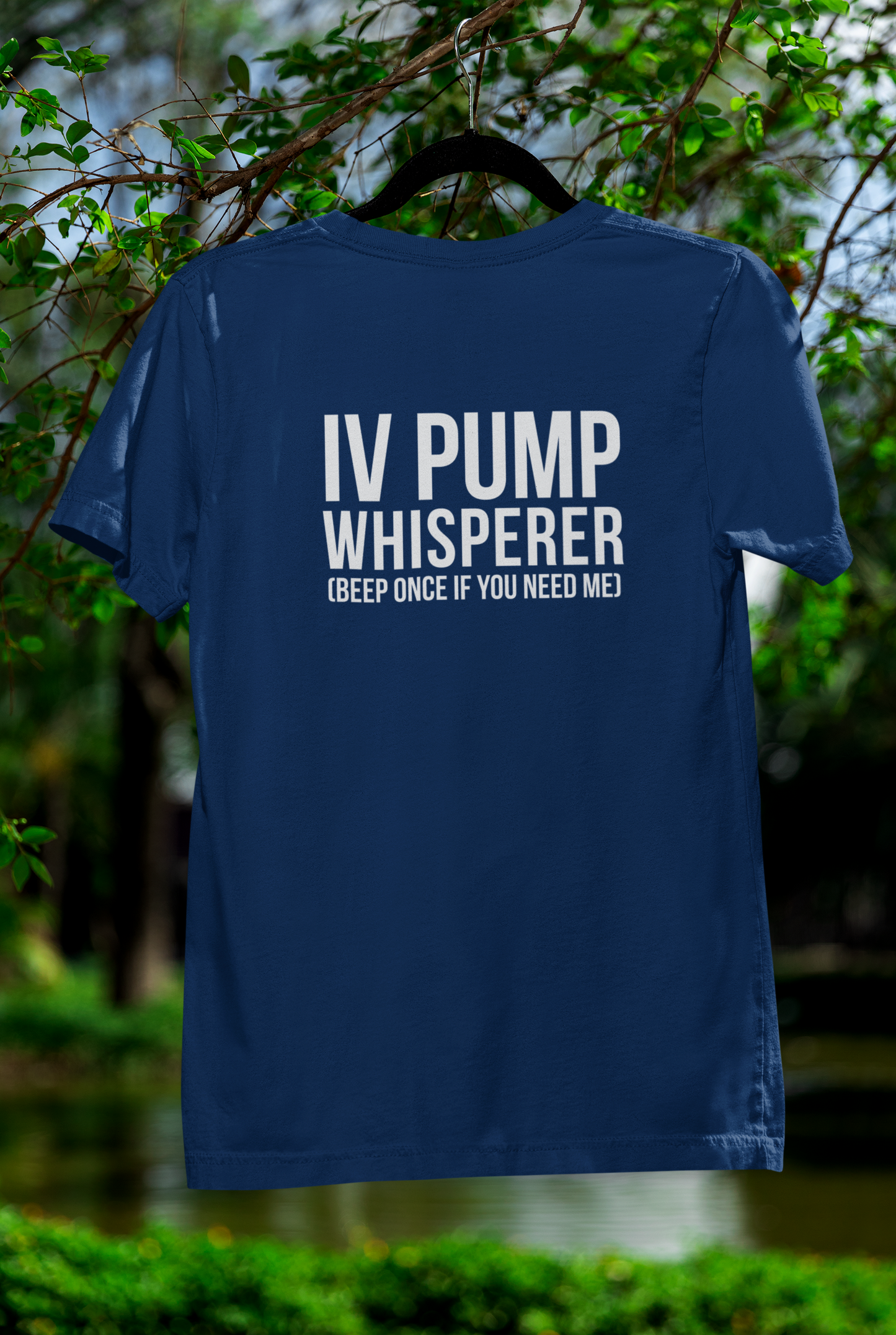 Backyard mockup of the IV Pump Whisperer shirt on a hanger outside.