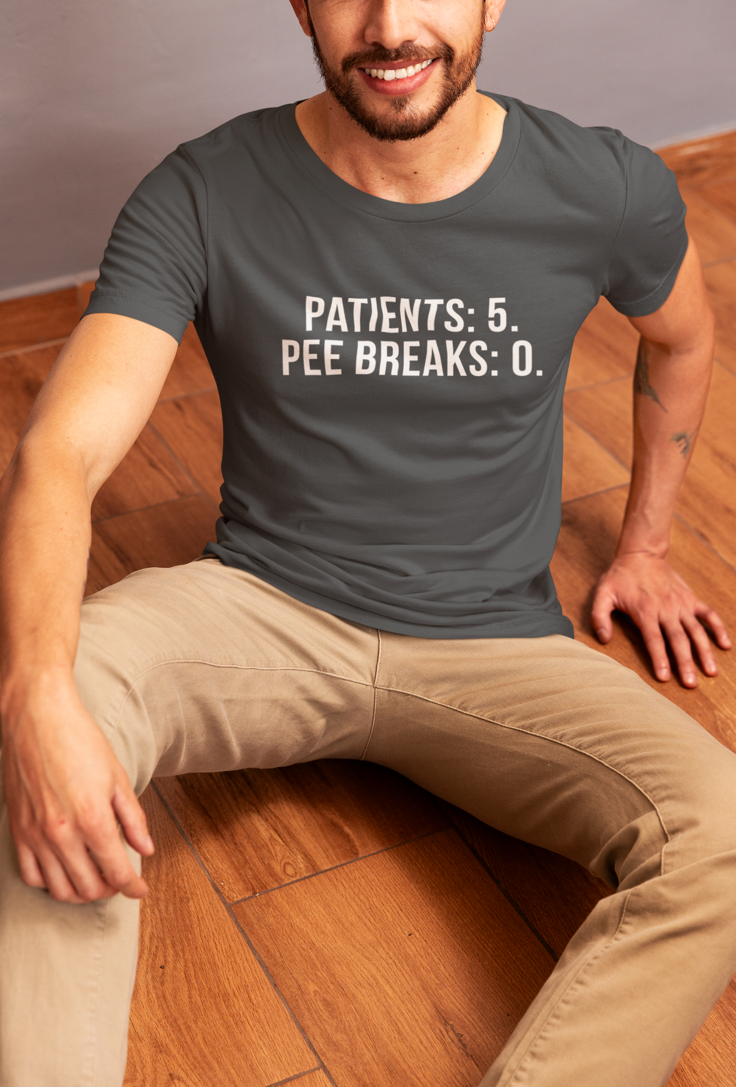 Nurse laughing in floor while wearing the “Patients: 5. Pee Breaks: 0.” shirt.