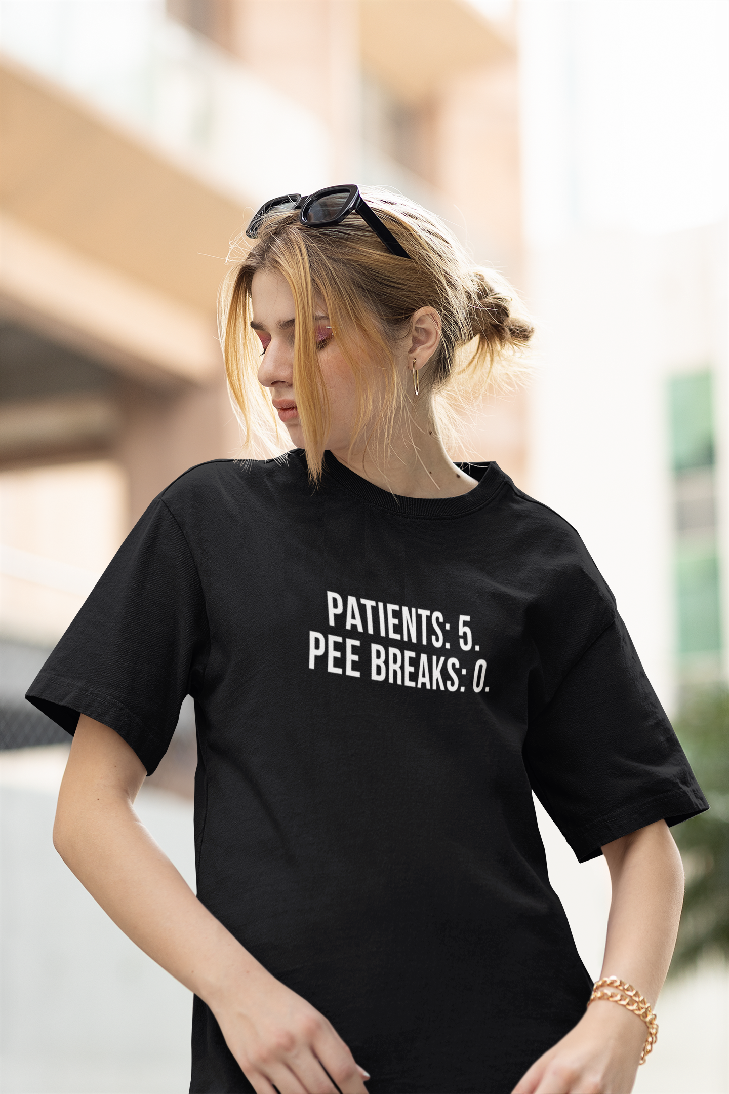 Funny nurse shirt with bold “Patients: 5, Pee Breaks: 0” design, worn by exhausted RN during hospital shift