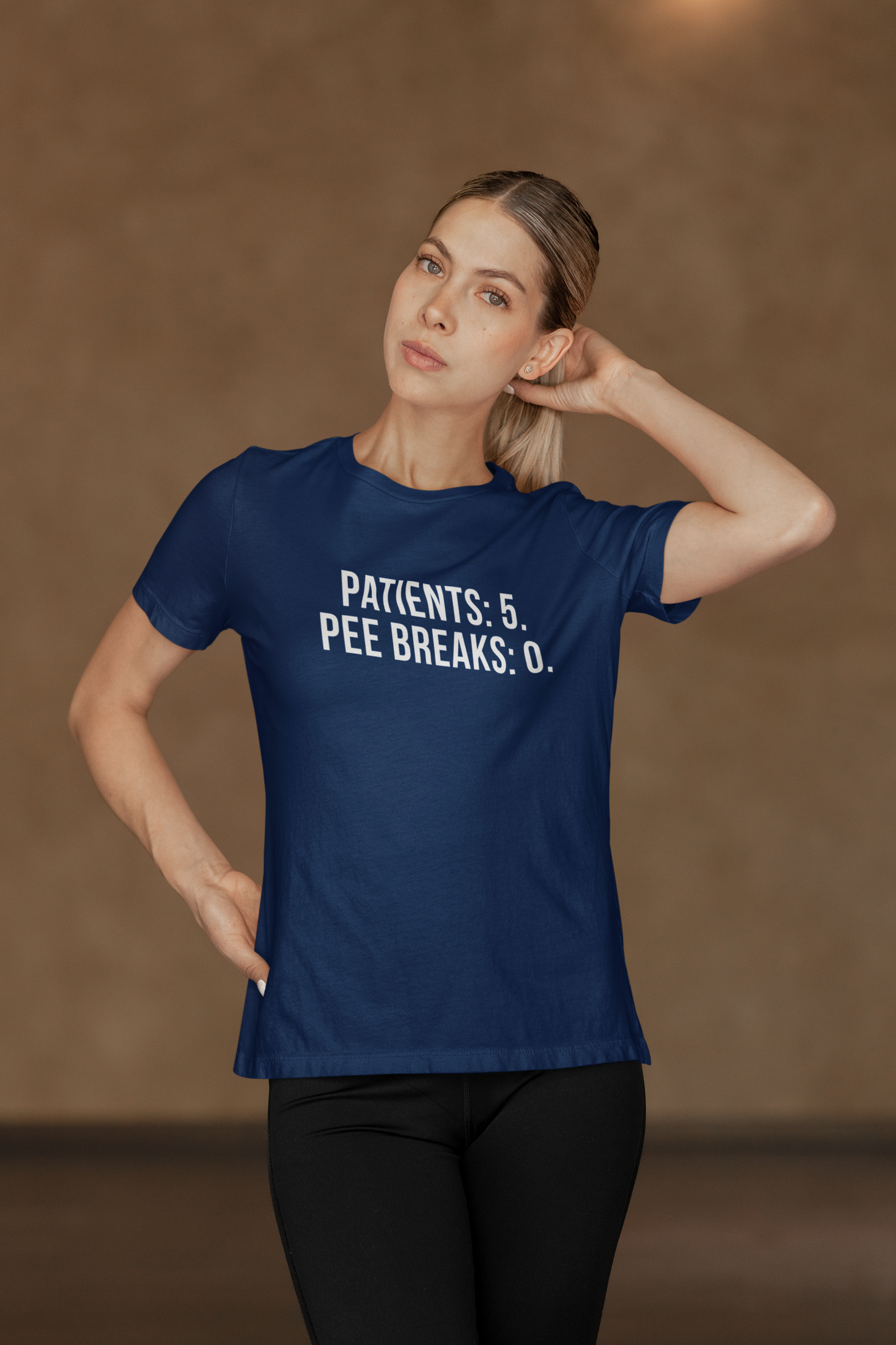 Nurse in yoga pose against hospital wall, repping the burnout tee with confidence.