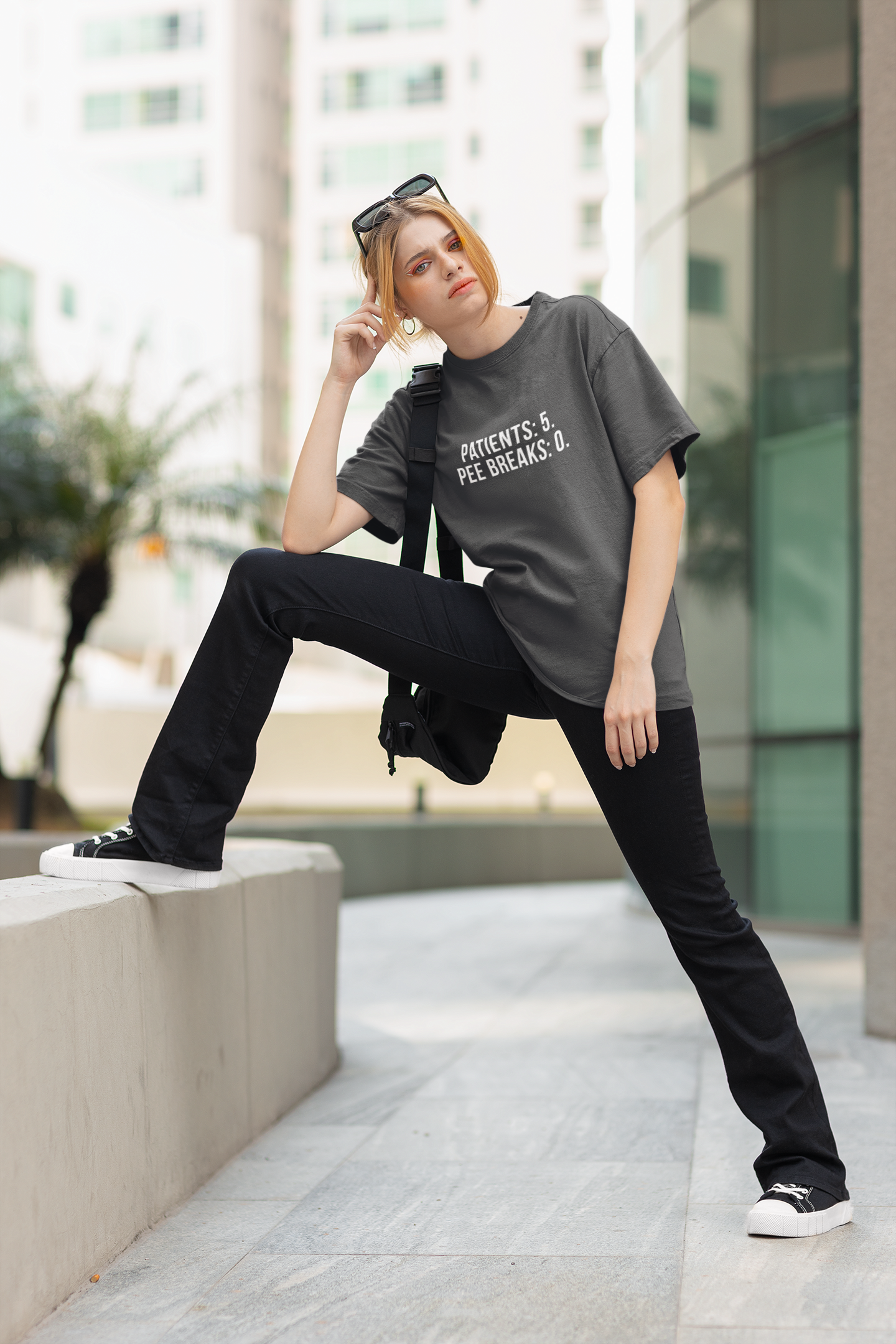 Nurse in yoga pose against hospital wall, repping the burnout tee with confidence.