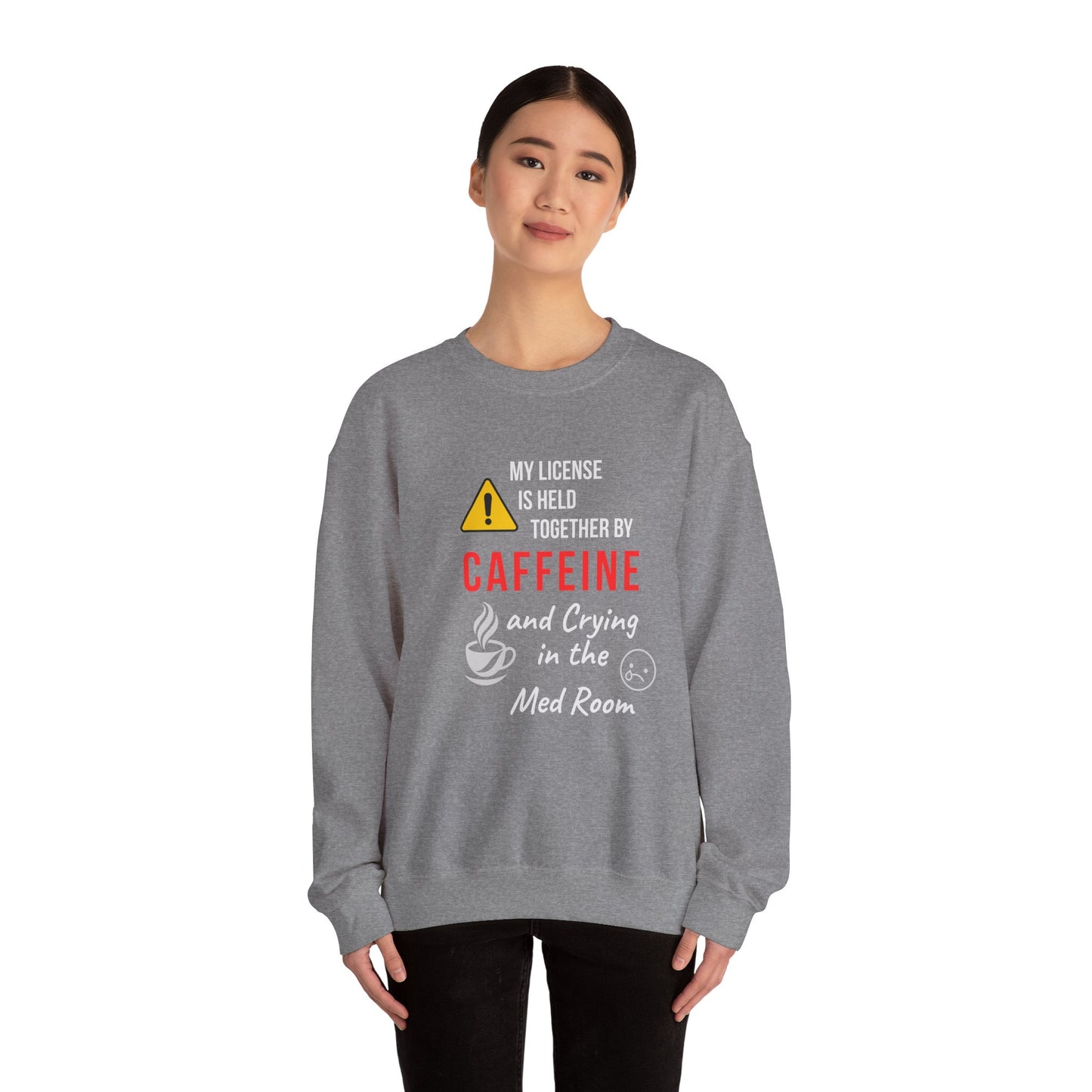 Funny nurse sweatshirt with quote “Held Together by Caffeine and Crying,” worn by exhausted RN mid-shift meltdown in breakroom
