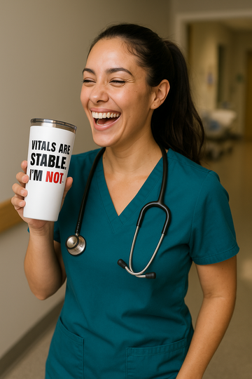 Asian nurse in teal scrubs laughing and holding tumbler that reads “Vitals Are Stable. I’m Not.” in a hospital setting
