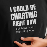 Close-up of shirt print: I Could Be Charting Right Now, bold white text on black fabric.