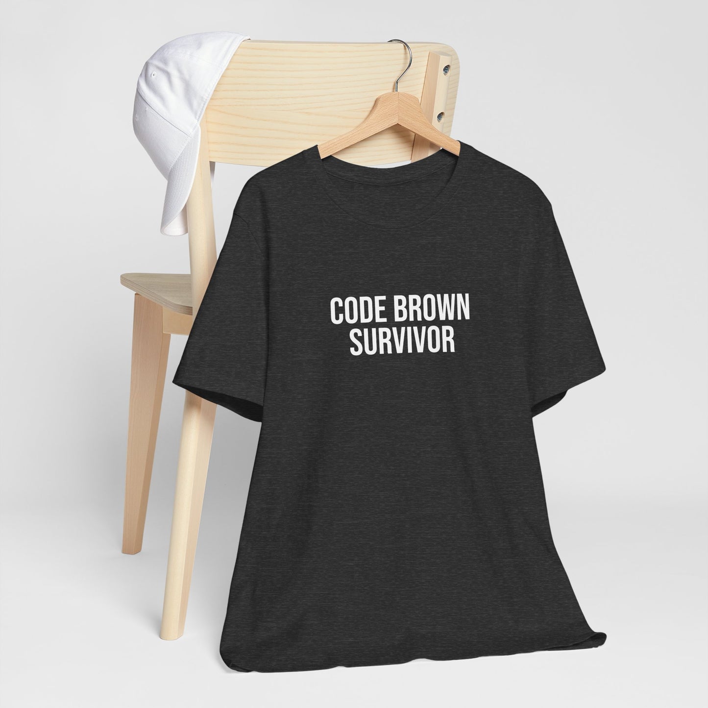 Black burnout tee with white “Code Brown Survivor” text on hanger.
