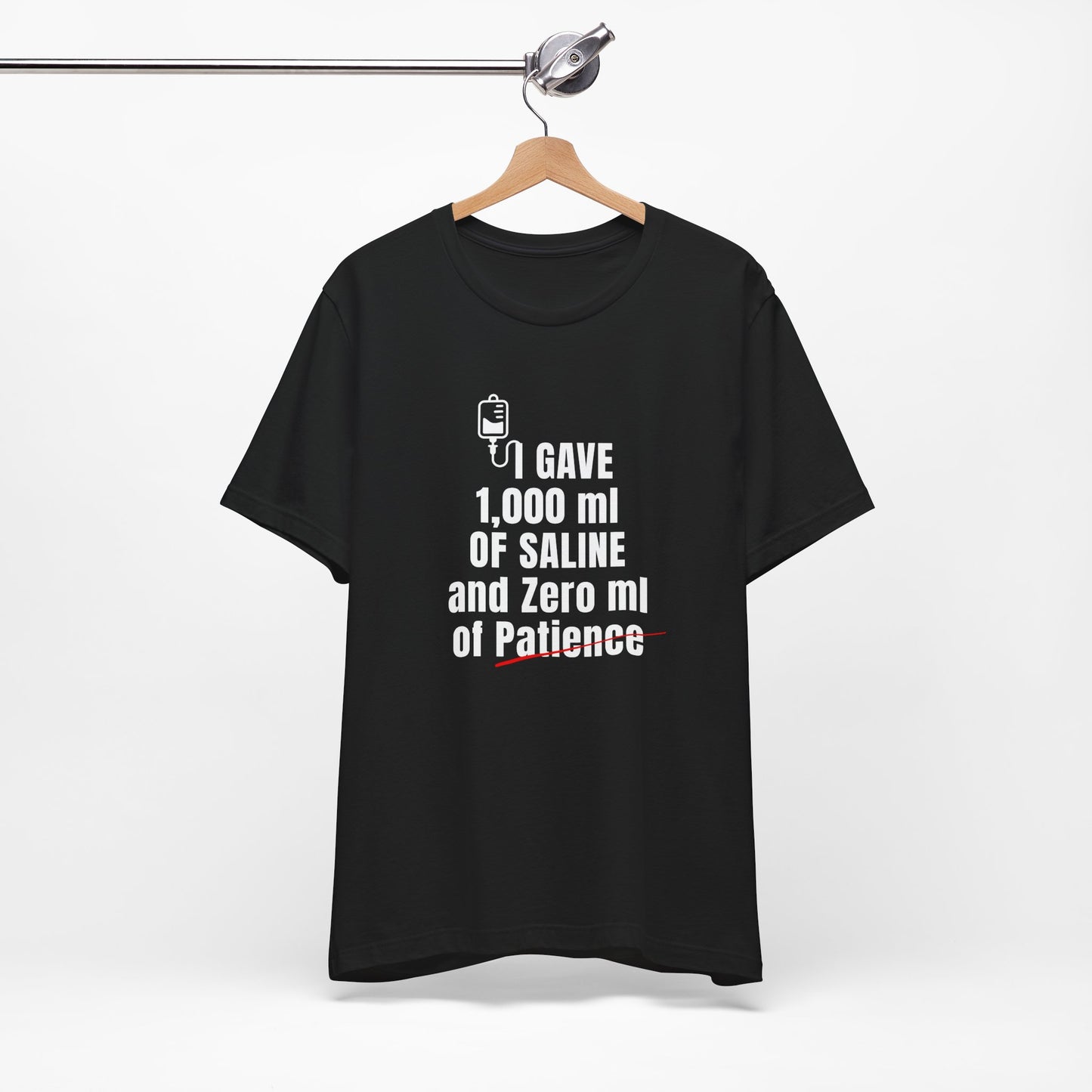 Black tee flat laid with IV humor punchline front and center—just like your attitude post-shift.
