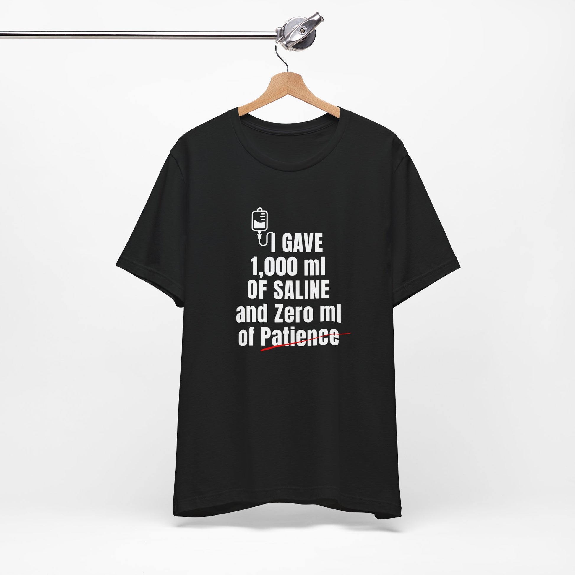 Black tee flat laid with IV humor punchline front and center—just like your attitude post-shift.
