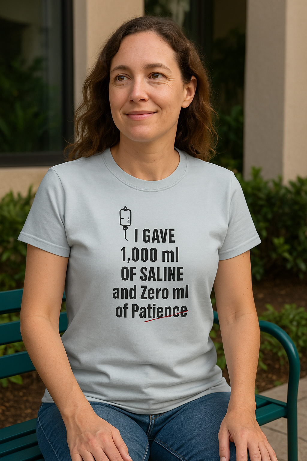 Nurse smiling at a coworker with a plant in the background, wearing the light blue tee like it’s therapy.
