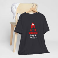 Black nurse humor shirt on hanger with warning triangle and bold text: NPO After Midnight Except for the Trauma.
