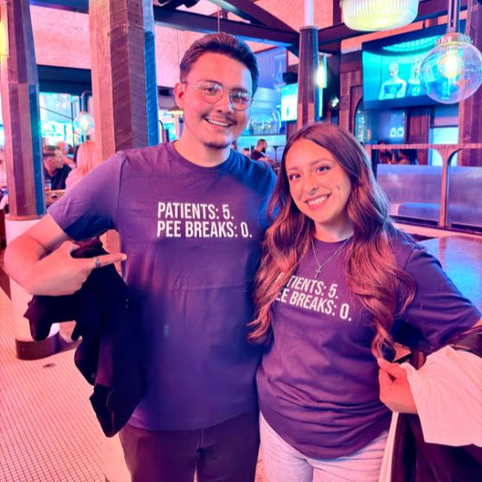 Funny nurse shirt with bold “Patients: 5, Pee Breaks: 0” design, worn by two nurses enjoying a night out