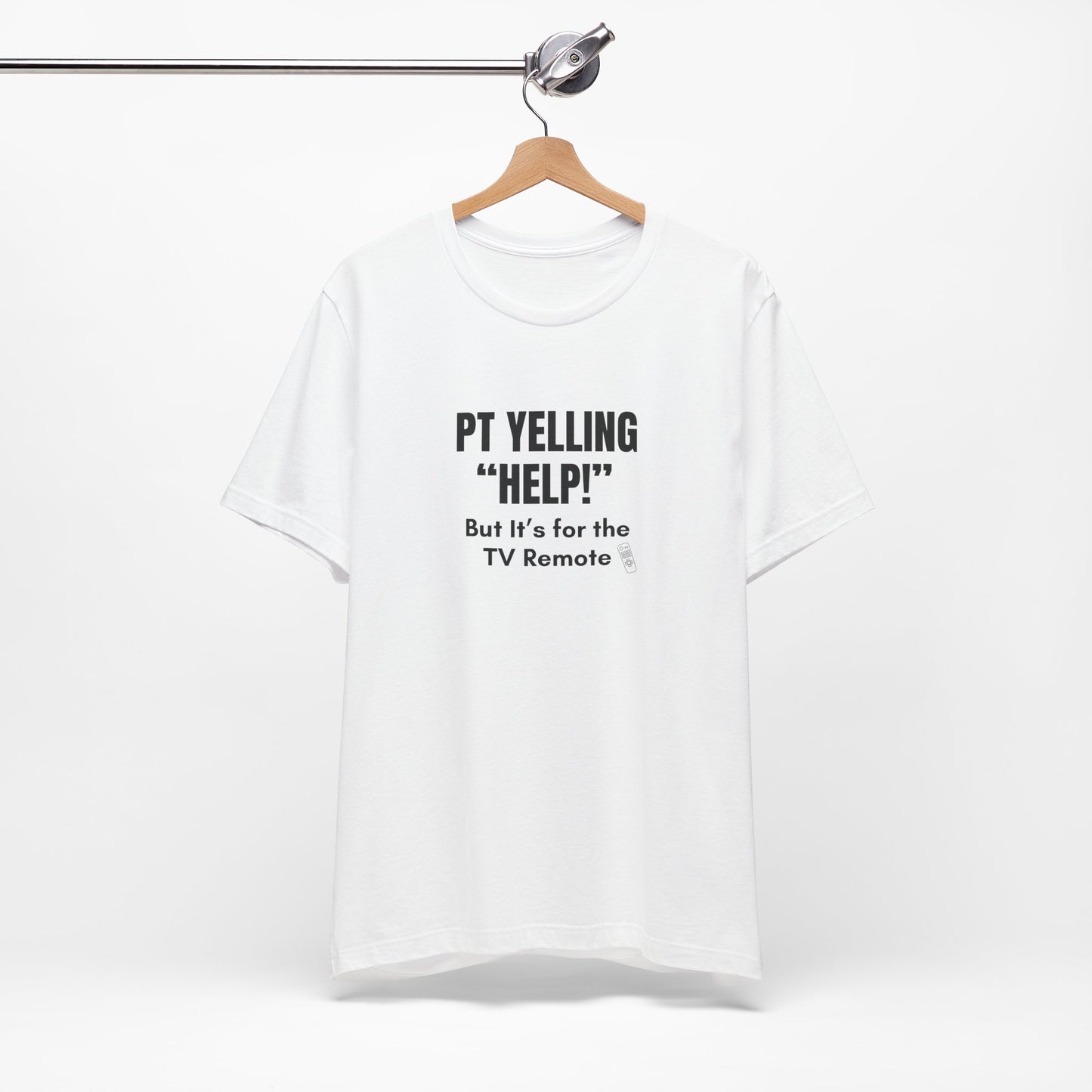 Flatlay of white “PT Yelling Help” nurse shirt hanging on a wooden hanger.
